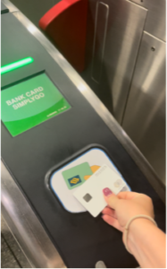 A hand holding a Journey MRT card in the Singapore Metro.