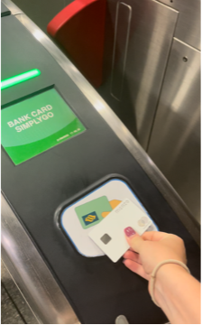 A hand holding a Journey MRT card in the Singapore Metro.
