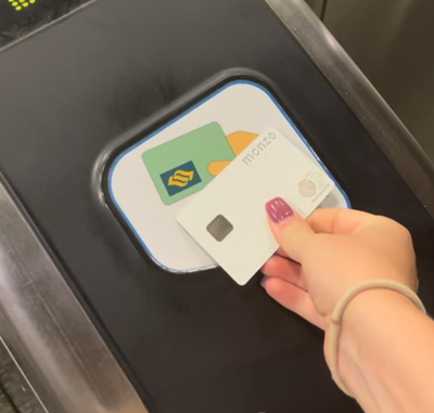 A woman scans her RFID Throughout my four weeks living in Singapore, Monzo card (an international and exchange rate friendly MasterCard) to pay for her travel.